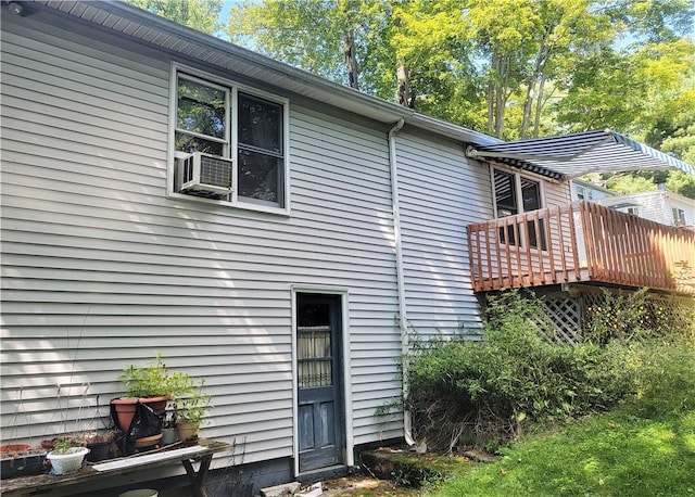 rear view of house featuring cooling unit and a wooden deck