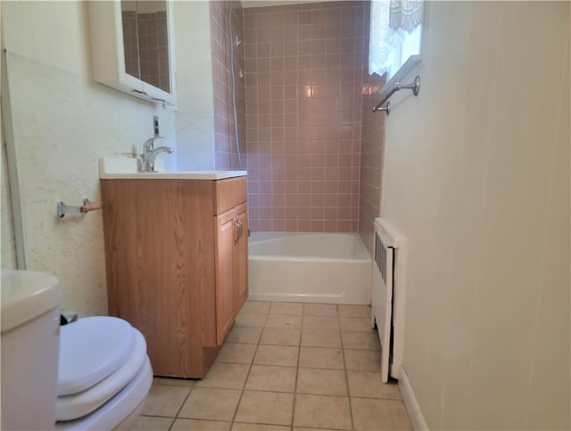 full bathroom featuring tile patterned floors, toilet, tiled shower / bath, and radiator