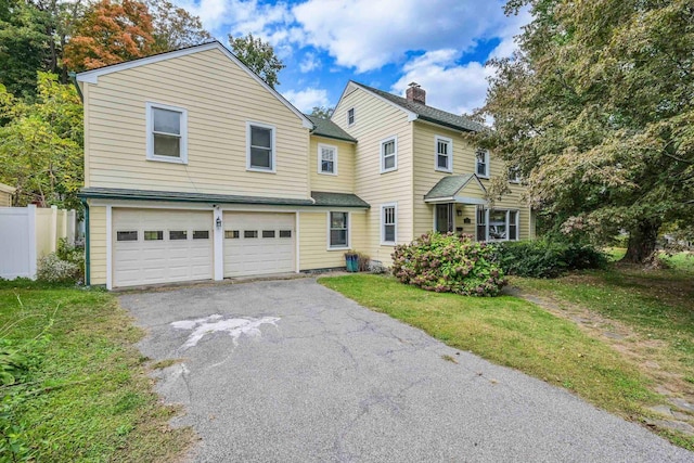 view of property with a front lawn and a garage