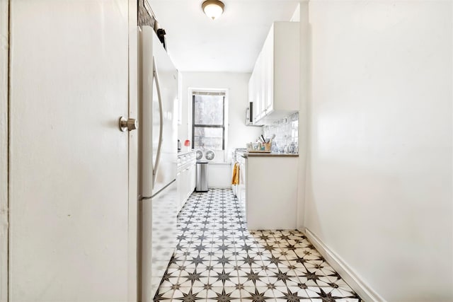 kitchen featuring white refrigerator and white cabinetry