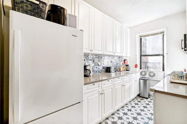 kitchen with white cabinets, decorative backsplash, and white refrigerator