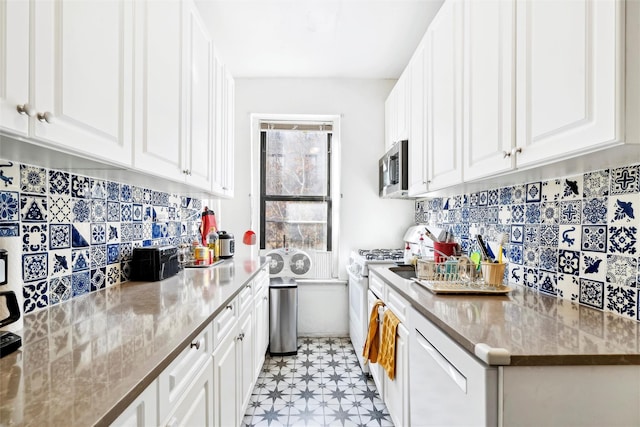 kitchen featuring white cabinets, white range oven, and dark stone countertops