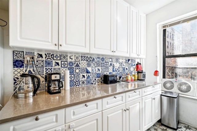 kitchen with stone countertops and white cabinetry