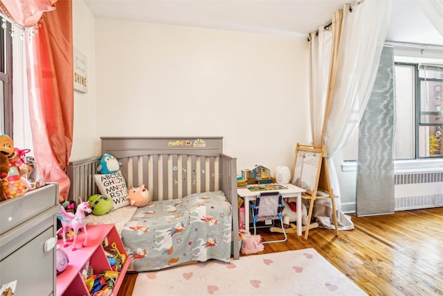 bedroom featuring hardwood / wood-style flooring and radiator