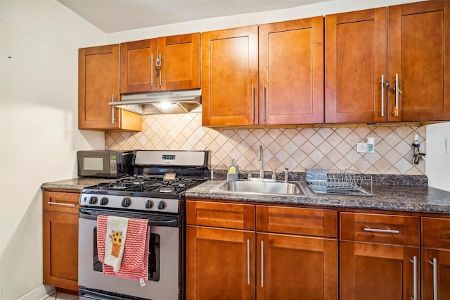 kitchen with decorative backsplash, stainless steel range with gas cooktop, dark stone countertops, and sink