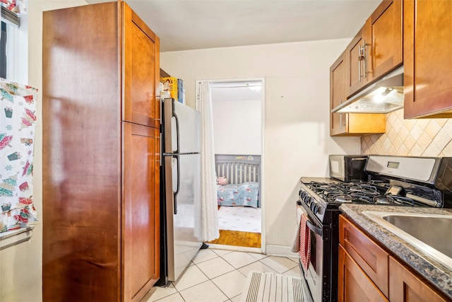 kitchen featuring light tile patterned flooring, appliances with stainless steel finishes, and tasteful backsplash