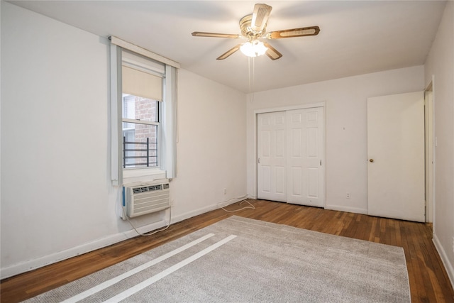 unfurnished bedroom with a wall mounted AC, ceiling fan, a closet, and dark hardwood / wood-style floors