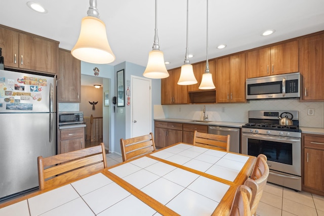 27 Stubbe Dr, Stony Point, NY 10980 - kitchen with stainless steel appliances, brown cabinetry, light tile patterned floors, and recessed lighting