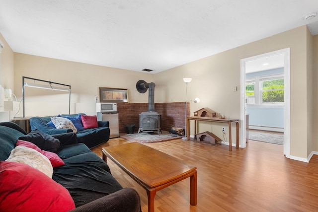 27 Stubbe Dr, Stony Point, NY 10980 - living area with wood finished floors, a baseboard radiator, and a wood stove