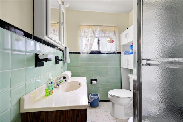 bathroom with tile patterned flooring, vanity, toilet, and tile walls