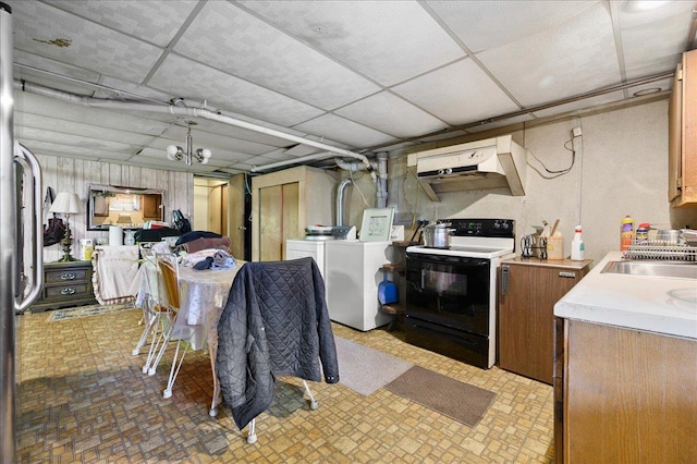 interior space with sink, a drop ceiling, separate washer and dryer, range hood, and white range with electric cooktop