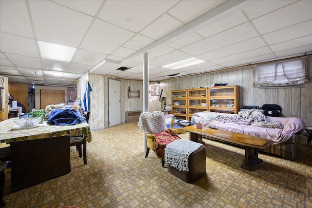 bedroom with a drop ceiling and wooden walls