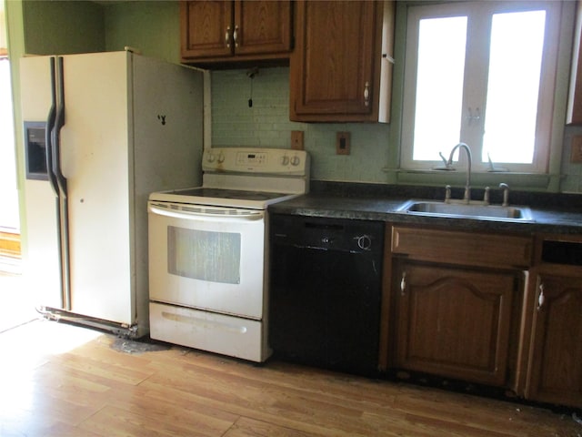 kitchen featuring tasteful backsplash, sink, light hardwood / wood-style floors, and white appliances