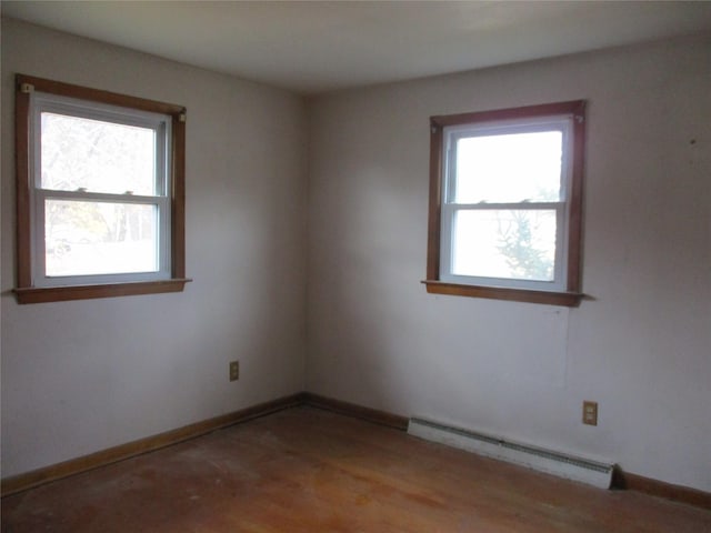 unfurnished room with plenty of natural light and a baseboard radiator