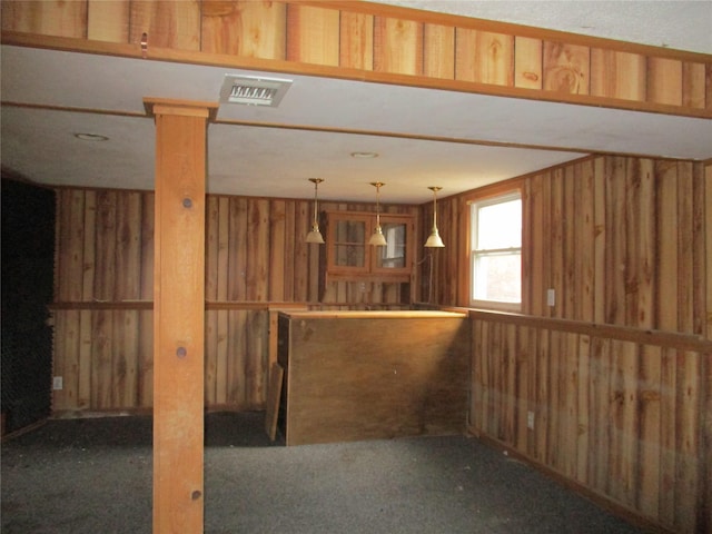 interior space with dark colored carpet and hanging light fixtures