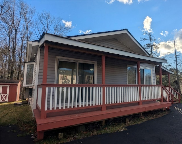 exterior space featuring a storage unit and covered porch