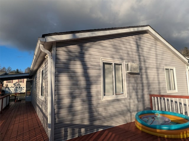 view of home's exterior featuring an AC wall unit and a wooden deck