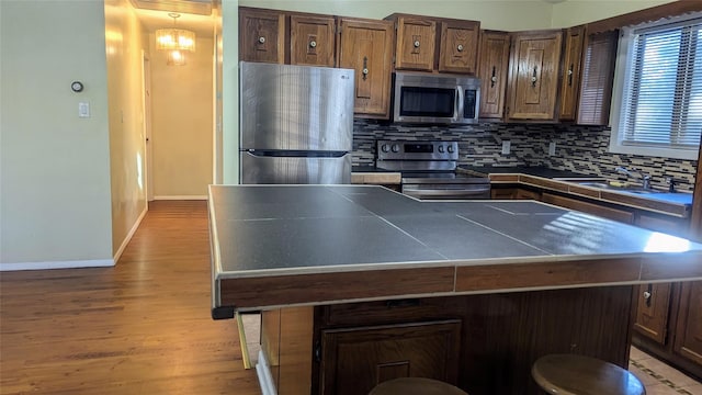 kitchen featuring a breakfast bar, sink, a center island, and appliances with stainless steel finishes