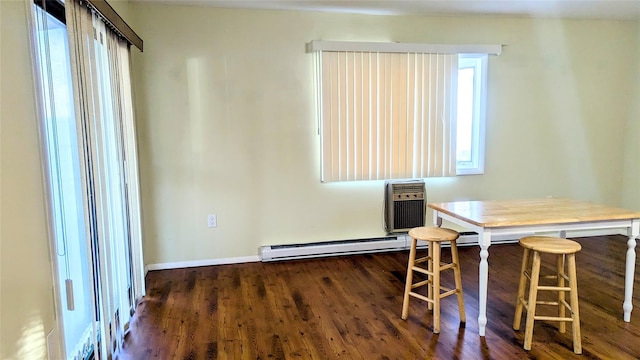 dining space featuring a wall unit AC and dark hardwood / wood-style flooring