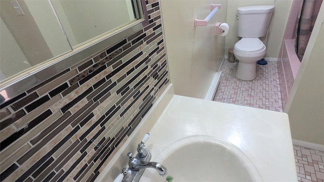 full bathroom with sink, shower / bathtub combination with curtain, and toilet