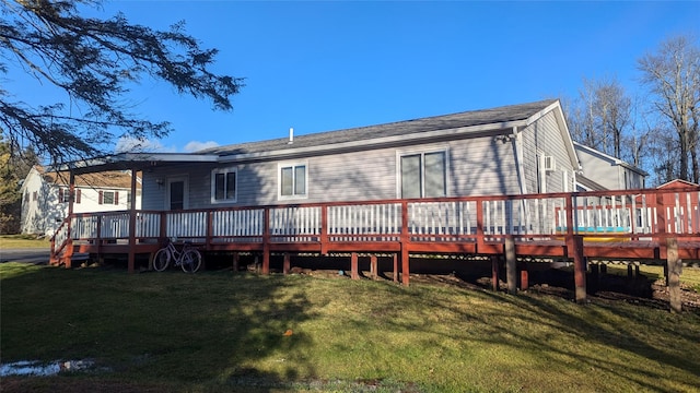 back of property featuring a lawn and a wooden deck