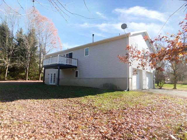 view of side of home with a lawn, a wooden deck, and a garage