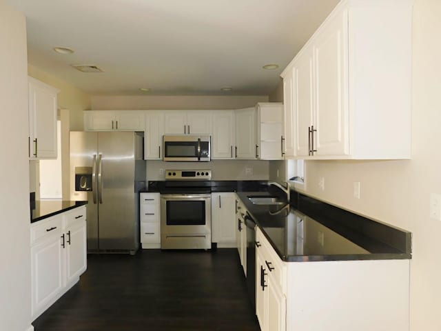 kitchen featuring dark hardwood / wood-style floors, white cabinetry, sink, and appliances with stainless steel finishes