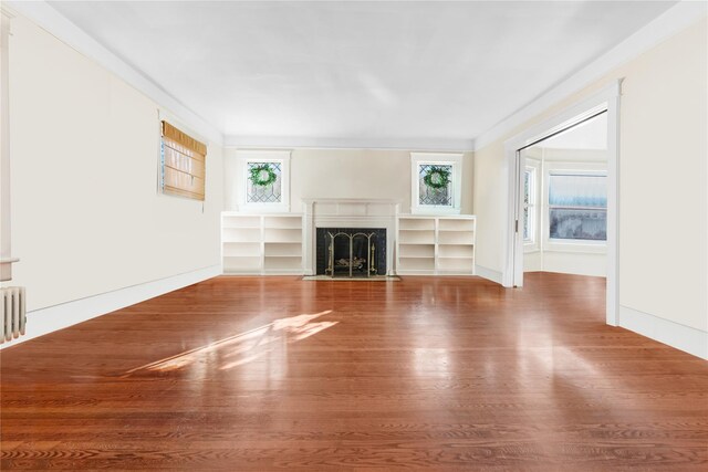 unfurnished living room with hardwood / wood-style floors and a premium fireplace