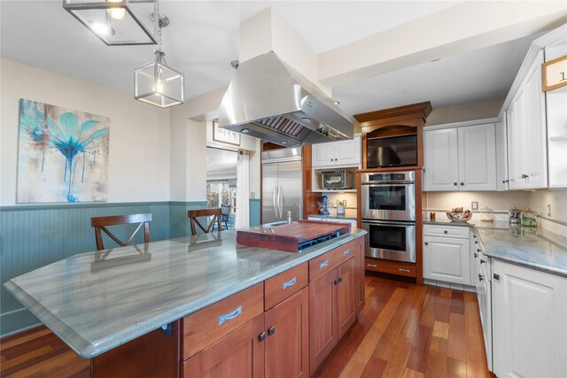 kitchen with a kitchen island with sink, a breakfast bar, white cabinets, and stainless steel appliances