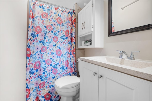 bathroom with vanity, a shower with shower curtain, and toilet