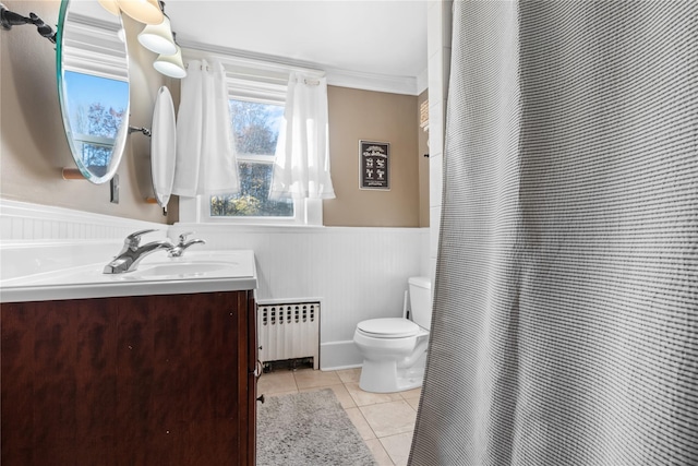 bathroom featuring vanity, radiator, tile patterned floors, toilet, and ornamental molding