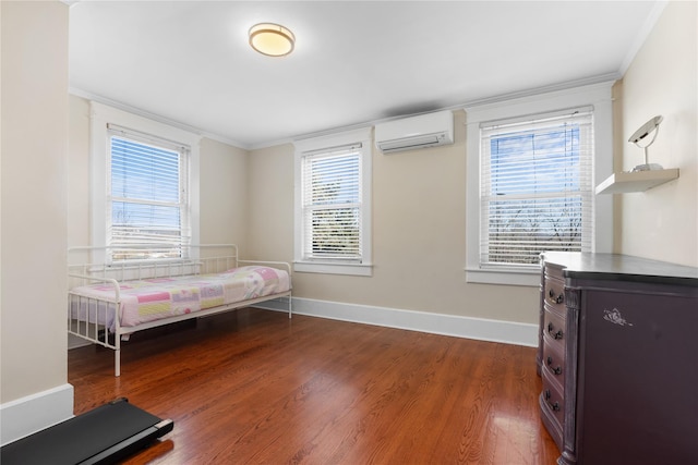 bedroom with hardwood / wood-style floors, a wall unit AC, and ornamental molding