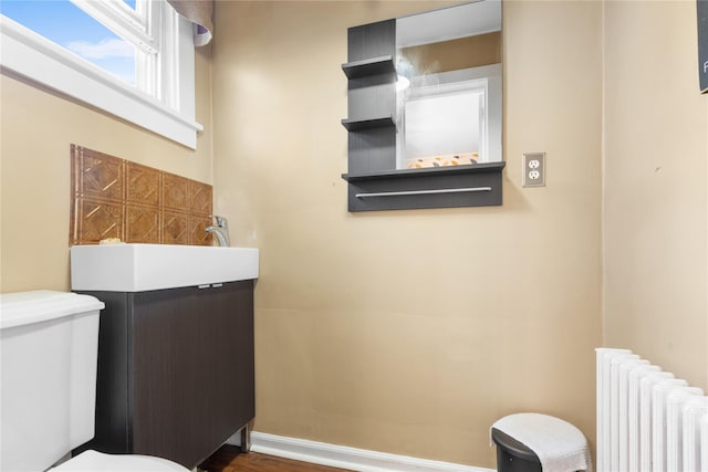 bathroom featuring radiator heating unit and wood-type flooring