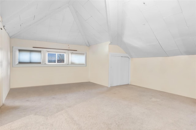 bonus room with light carpet and lofted ceiling