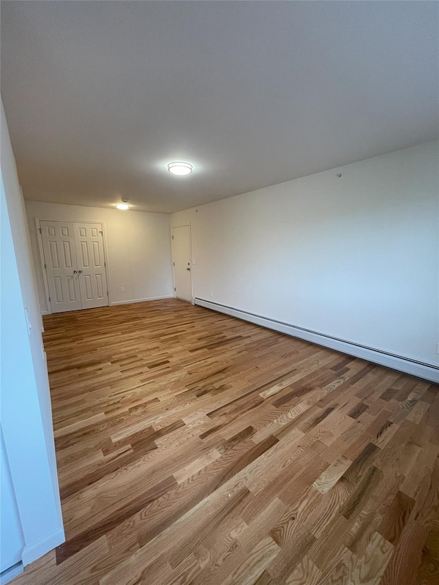 spare room with light hardwood / wood-style floors and a baseboard heating unit