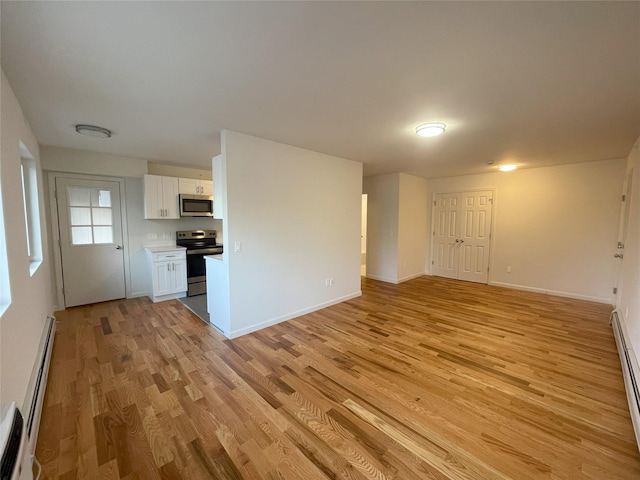 unfurnished living room featuring a baseboard radiator and light hardwood / wood-style flooring