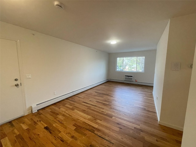 empty room with wood-type flooring and a baseboard heating unit