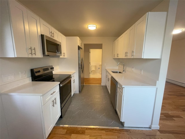 kitchen with dark hardwood / wood-style flooring, white cabinetry, and stainless steel appliances