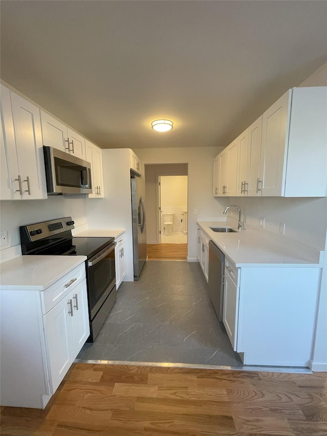 kitchen with white cabinetry, dark hardwood / wood-style flooring, and appliances with stainless steel finishes