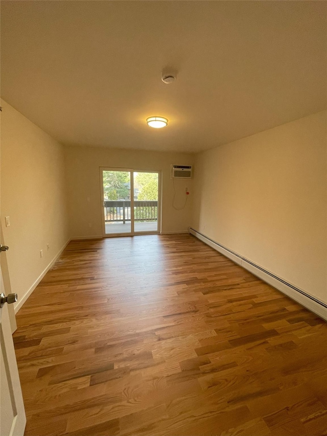 empty room featuring a wall mounted air conditioner and light wood-type flooring