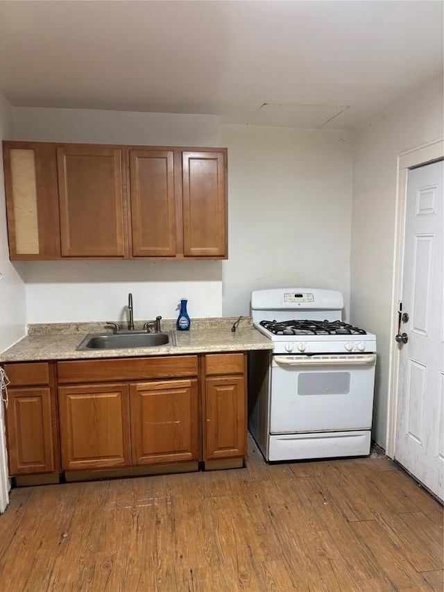 kitchen featuring wood-type flooring, sink, and white range with gas stovetop