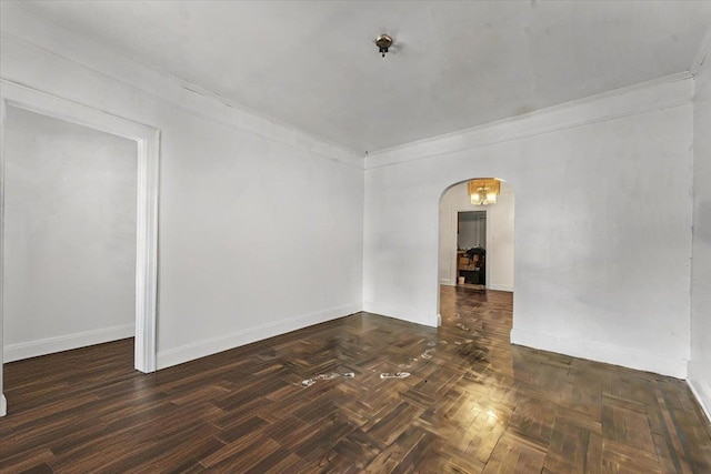 spare room with ornamental molding and dark parquet flooring