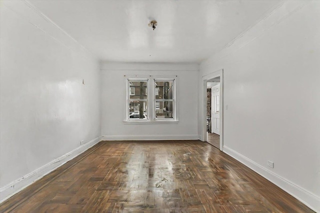 spare room featuring dark parquet floors