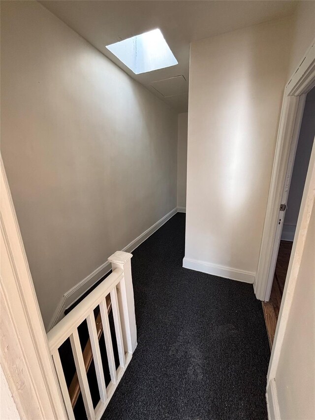 corridor with a skylight and carpet floors