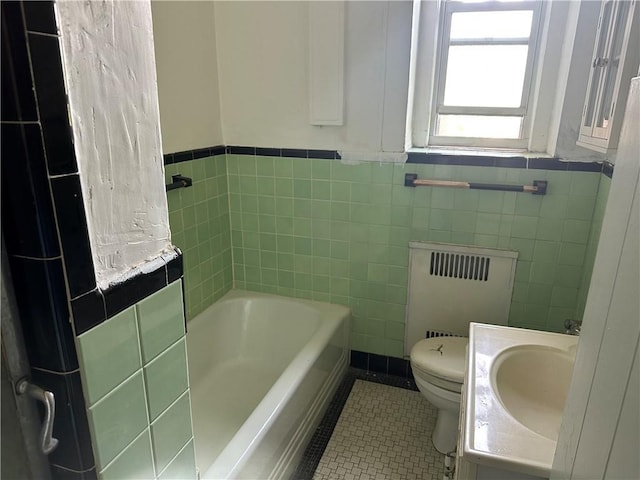 17506 Devonshire Blvd Unit 4C, Jamaica Hills, NY 11432 - bathroom with radiator, a bathtub, toilet, tile patterned flooring, and tile walls