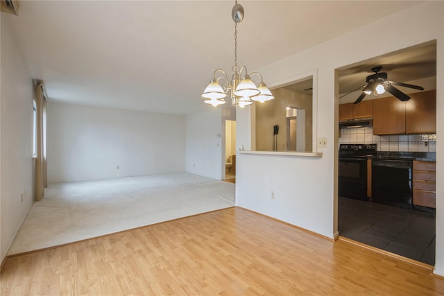 interior space featuring light hardwood / wood-style flooring, decorative light fixtures, decorative backsplash, black appliances, and ceiling fan with notable chandelier