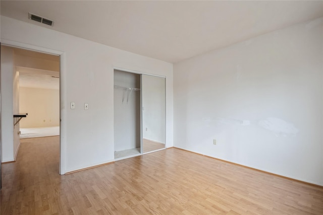 unfurnished bedroom featuring a closet and hardwood / wood-style flooring