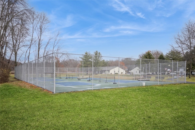 view of tennis court featuring a yard