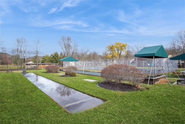 surrounding community featuring a yard and tennis court