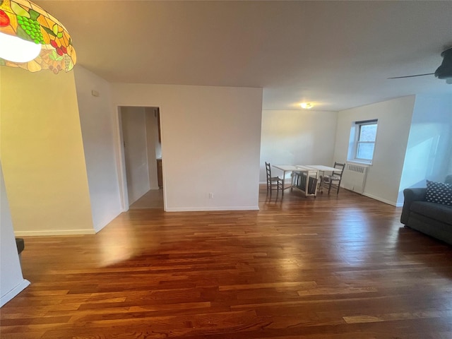 unfurnished living room with radiator heating unit and dark wood-type flooring